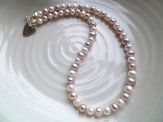 Love, kindness, happiness are all encompassed in this timeless pink freshwater pearl necklace. Perfect for a bride or bridesmaid and with a choice of clasps, this piece of jewellery has been lovingly handmade in the UK and is nickel-free. The pearl necklace will add a hint of romance to any outfit with its subtle nuances of pink enhancing their natural beauty. Matching earrings or a bracelet are also available so perhaps treat her to a set as a stunning keepsake gift. FEATURES: * genuine pink an Classic Pink Pearl Drop Necklace, Delicate Pink Pearl Necklace For Wedding, Pink Round Bridal Necklace For Anniversary, Pink Pearl Charm Necklace For Wedding, Wedding Pink Pearl Charm Necklace, Pink Round Pearl Necklace Gift, Elegant Pink Pearl Necklace For Anniversary, Pink Round Bead Pearl Necklace For Wedding, Pink Round Pearl Drop Necklace