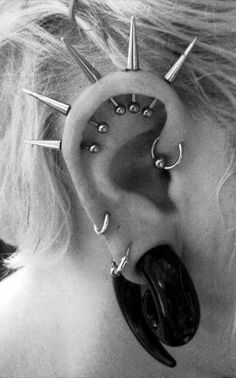 black and white photograph of a woman's ear with spikes in the shape of an ear