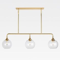 three light brass track lighting with clear glass globes on the bottom and gold metal bar