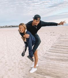 a man and woman are dancing on the beach