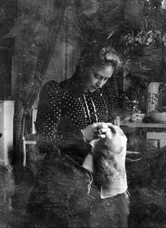 an old photo of a woman holding a cat