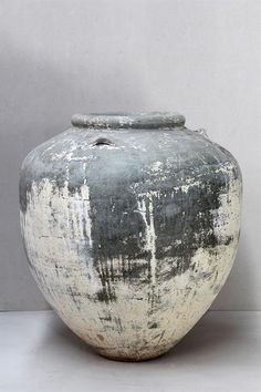 a large gray vase sitting on top of a white table