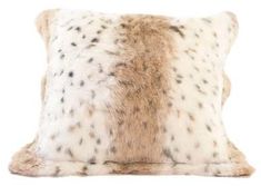 a white and brown pillow with black spots on the front, sitting against a white background