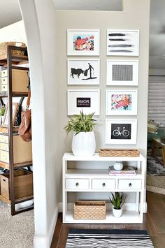 a living room with pictures on the wall and a rug in front of an entryway