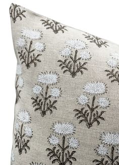 a white and black pillow with flowers on it