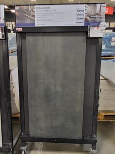 two black metal racks with signs on them in a store display area, one is empty and the other is closed