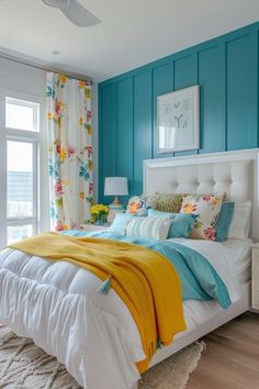 a bedroom with blue walls, white bedding and yellow throw blanket on the bed