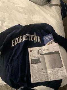 a newspaper laying on top of a bed next to a pillow