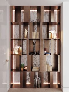 a book shelf with many books and vases on it in front of a marble wall