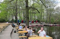 people are sitting at picnic tables near the water