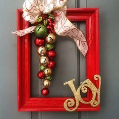 a christmas ornament hanging on a red frame with the word joy spelled out