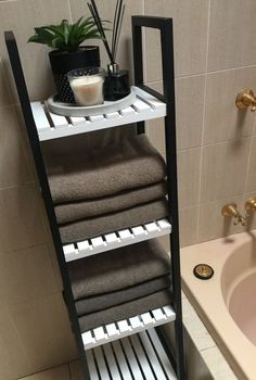 a bathroom with a sink, towel rack and bathtub in it's corner