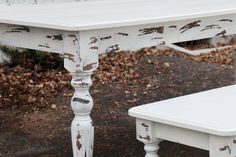 an old white table and bench sitting outside