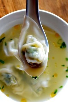 a spoon full of soup with dumplings in it