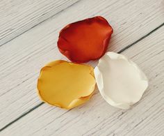 three pieces of paper sitting next to each other on a white table with red and yellow ribbons