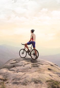 a man riding a bike on top of a rocky mountain with the words every accomplishment starts with the decision to try