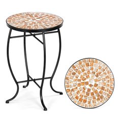 an orange and white mosaic table next to a black stand with a plate on it