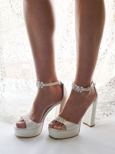 a woman's legs wearing high heels and pearls