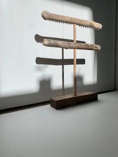 a sculpture made out of wooden sticks on top of a white table next to a window