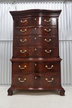 an antique chest of drawers with brass handles