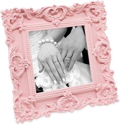 a pink frame with two hands holding the bride's hand and wedding rings on it