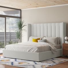 a bedroom with a bed, dresser and large window looking out onto the balcony area