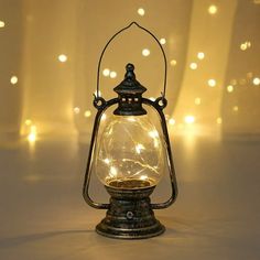 an old fashioned lantern is lit up with fairy lights