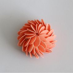 an orange flower sitting on top of a white table