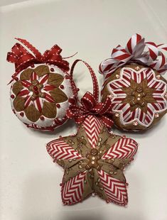 three christmas ornaments are sitting on a white counter top, one is decorated with candy canes and the other has snowflakes