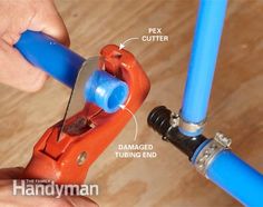 a person is fixing a pipe with blue piping hoses and an orange wrench