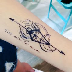 a woman's arm with an arrow and time waits for no one tattoo on it