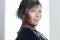 a woman with grey hair is looking at the camera