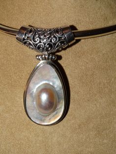 "Vintage RARE made in Mexico Sterling Silver awesome Mabe Blister Pearl Necklace with an iridescent White gray sheen wrapped in solid sterling silver, 13.5\", the Blister Pearl dangling Hinged slide piece size is 2.5\" x 1.20\" excellent condition." Unique Silver Mother Of Pearl Jewelry, Silver Oval Pearl Drop Necklace, Silver Oval Necklace With Pearl Drop, Unique Formal Mother Of Pearl Jewelry, Silver Oval Mother Of Pearl Jewelry, Oval Silver Mother Of Pearl Jewelry, Oval Mother Of Pearl Silver Jewelry, Silver Pearl Pendant Jewelry In Mother Of Pearl, Elegant Iridescent Jewelry With Pearl Pendant