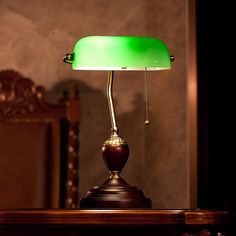 a green lamp sitting on top of a wooden table