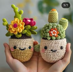 two small crocheted pots with flowers on their heads, one holding the other