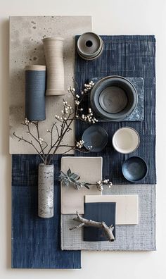 the table is set with blue and white plates, cups, vases and other items