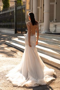 a woman in a wedding dress standing on steps