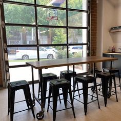 a kitchen table with four stools and a basketball hoop in front of the window