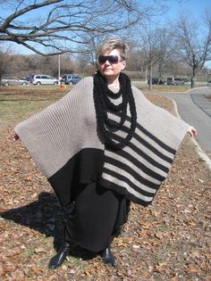 a woman standing on the side of a road wearing a shawl