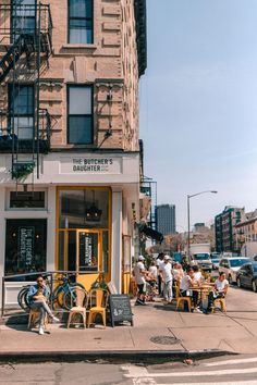 people sitting at tables in front of a building