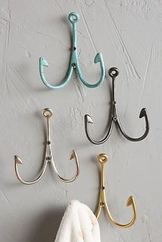 three hooks are hanging on the wall next to each other and one hook is holding two umbrellas