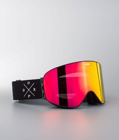 a pair of ski goggles sitting on top of a white table next to a wall