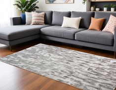 a living room with a gray couch and rug on the floor next to a window