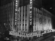 the radio city building is lit up at night