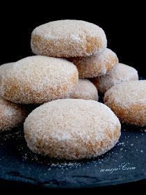 a pile of sugar covered donuts sitting on top of a black plate