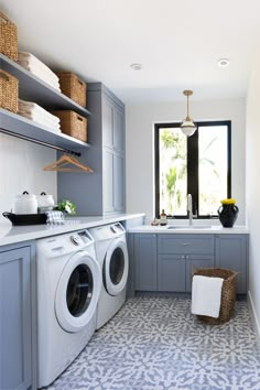 a washer and dryer in a laundry room next to a window with open shelving