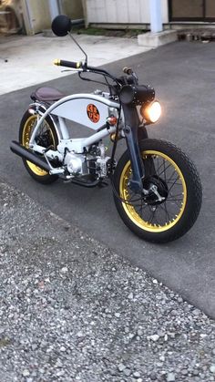 a motorcycle parked on the side of a road next to a parking lot with no one around it