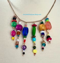 Elevate your jewelry game with this colorful multi-beaded charm necklace. This stunning piece features a unique blend of multi-colored beads in a variety of shapes and sizes. At 20 inches in length, it is a versatile addition to your wardrobe that can be worn all year round. Not only will it add a pop of color to any outfit, but it also showcases your trendsetting and outgoing style. You don't have to break the bank to own this handmade necklace, making it perfect for those looking for affordabl Cheap Trendy Multi-strand Charm Necklaces, Rainbow Necklaces With Spacer Beads For Jewelry Making, Multicolor Wooden Beads Necklaces For Jewelry Making, Rainbow Colorful Beads Necklaces For Jewelry Making, Rainbow Colorful Beaded Necklaces For Jewelry Making, Multicolor Wooden Beads For Jewelry Making, Rainbow Jewelry With Large Beads For Jewelry Making, Multicolor Dangle Beaded Necklaces In Bohemian Style, Multicolor Beaded Necklaces With Dangling Beads