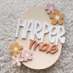 a wooden sign that says, harper mae with flowers on the bottom and letters above it