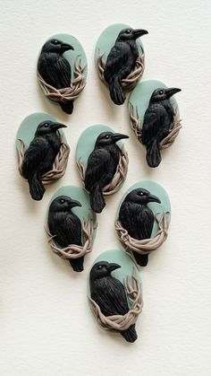 six black birds sitting on top of each other in the middle of a circle with branches around them